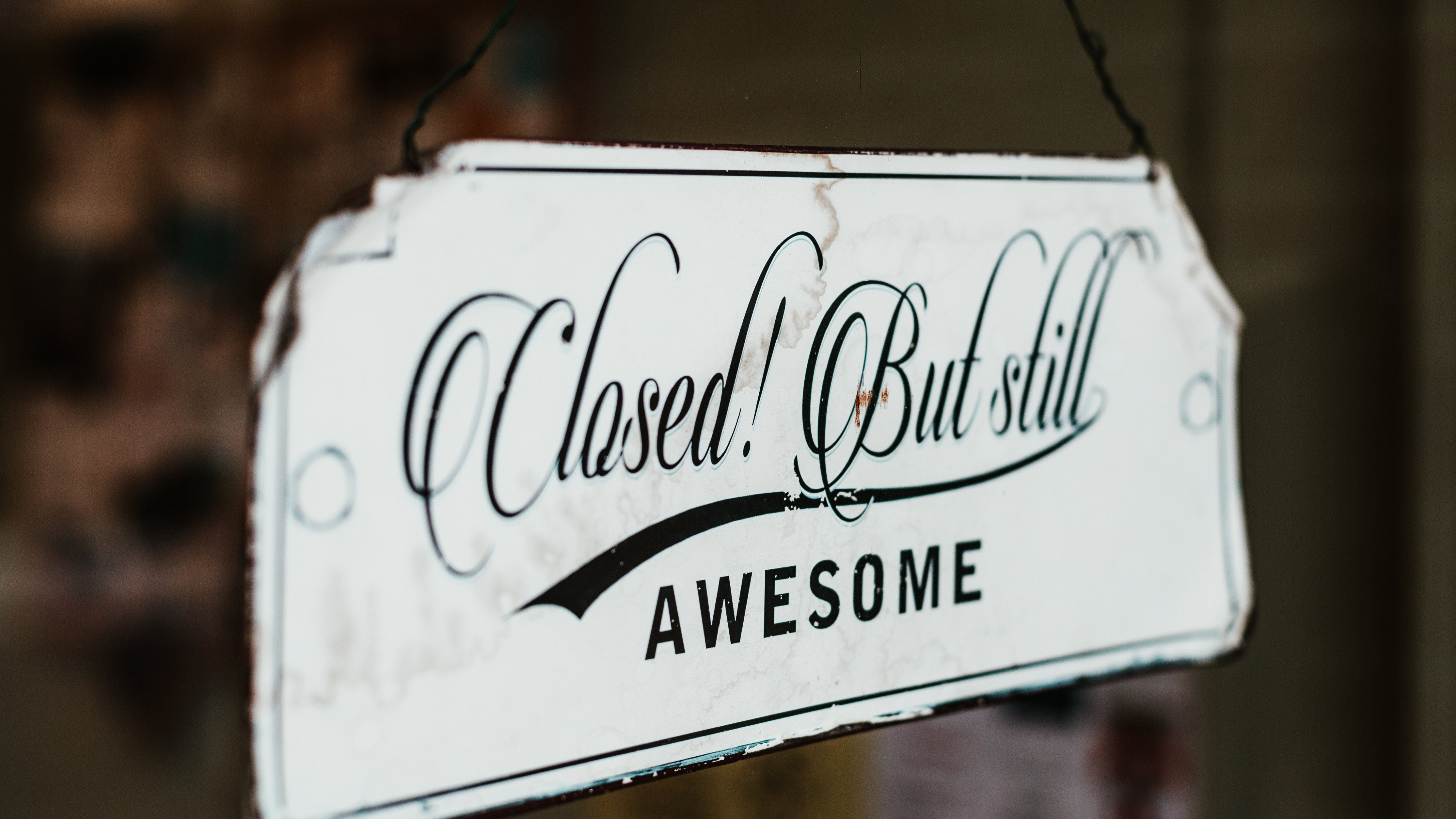 A closeup shot of a sign saying "Closed but still awesome".