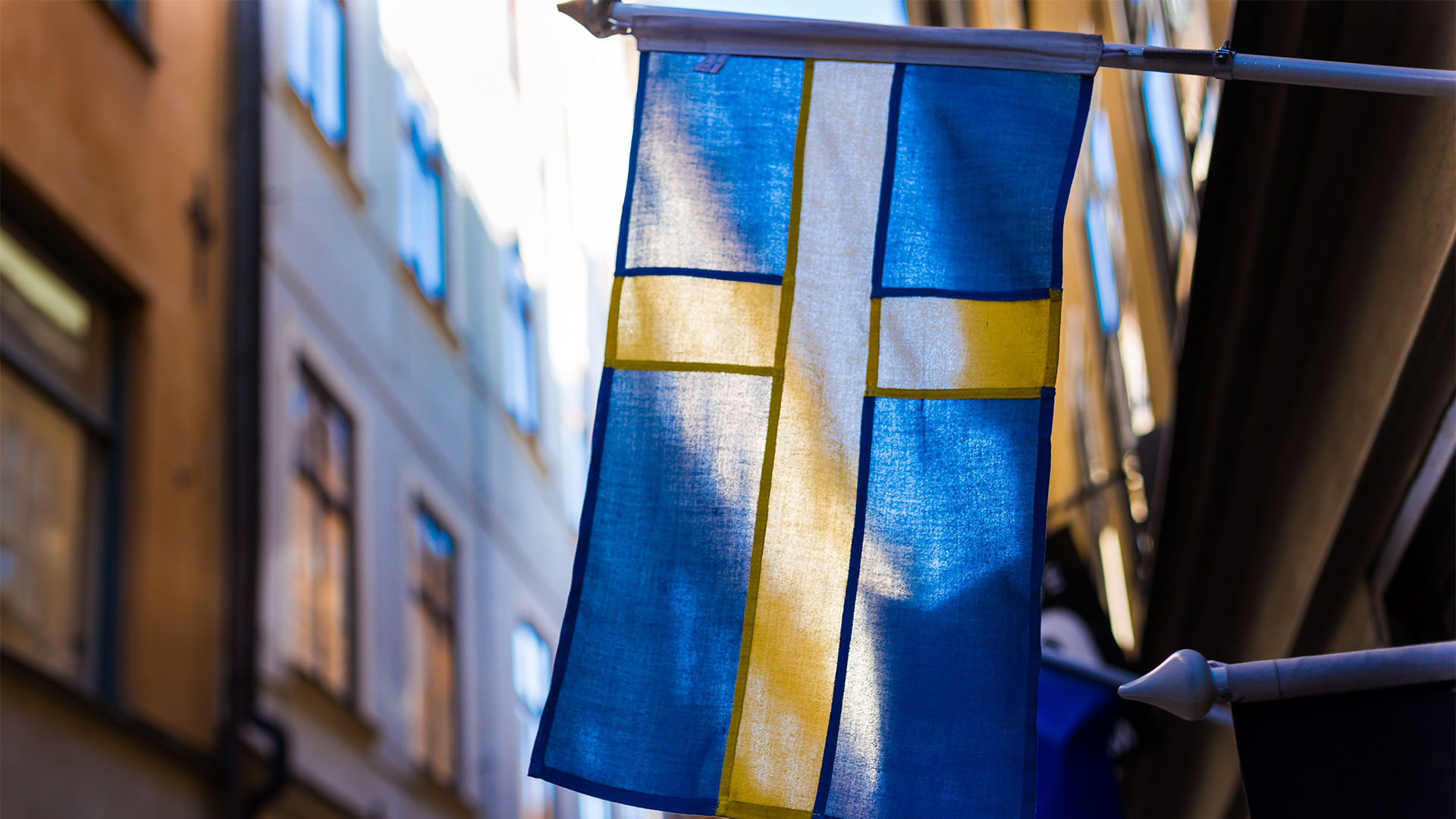 A close shot of Sweden national flag hanging on a Sweden street.