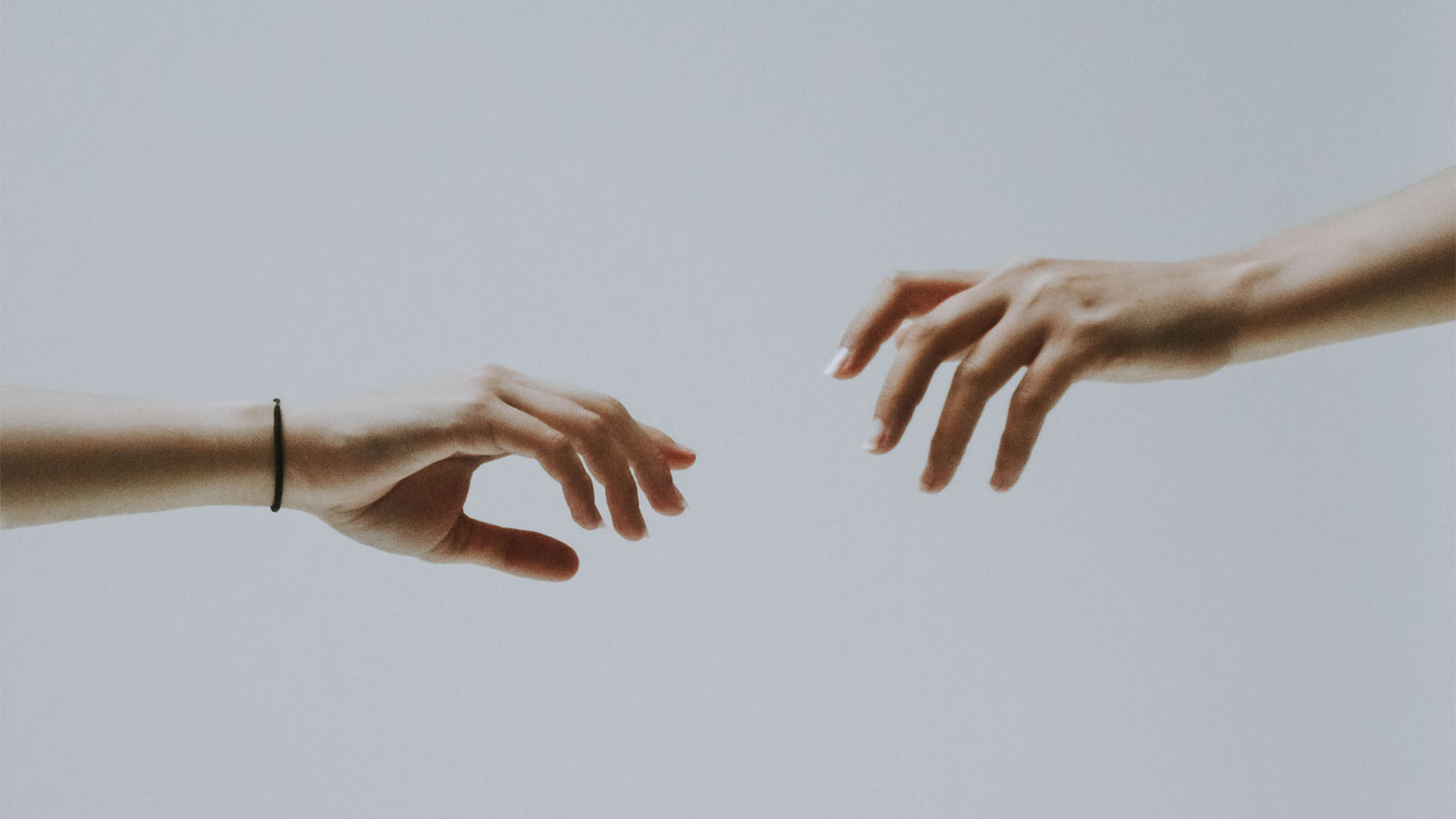 Two hands reaching out for each other.